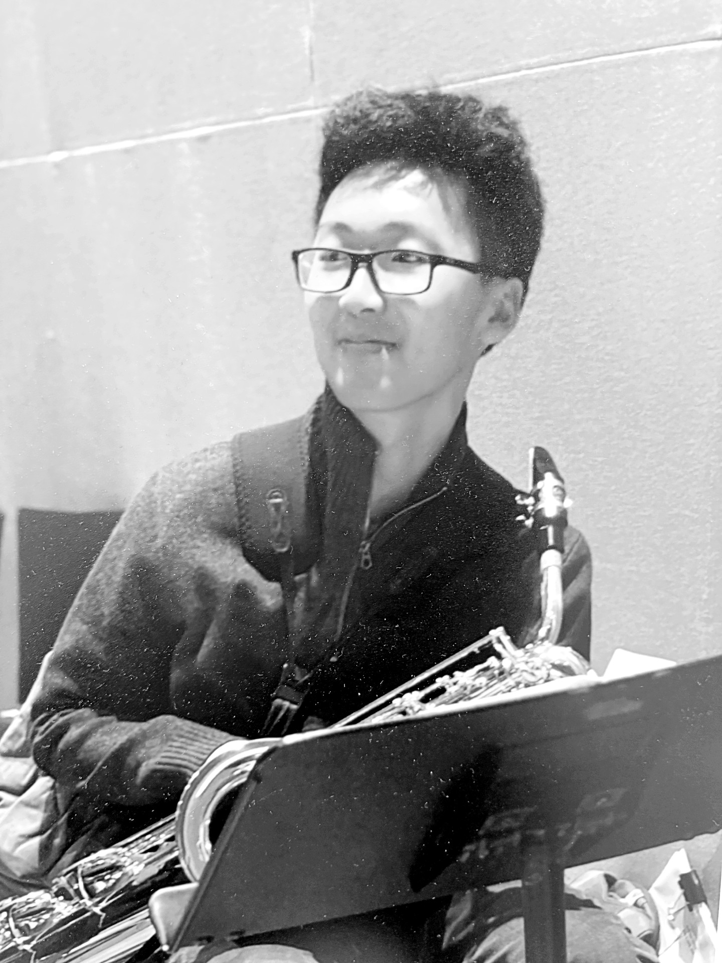 Micah Lim holding a saxophone at a music stand